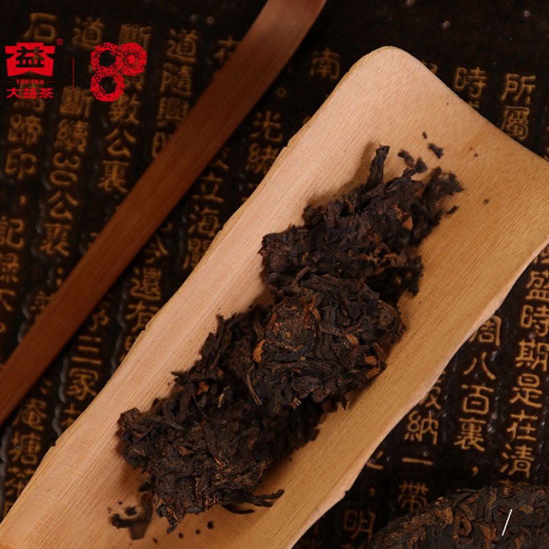 Broken piece of Wang Fu ripe pu-erh cake showing aged dark leaves